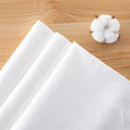 White textured travel towels arranged on a wooden surface